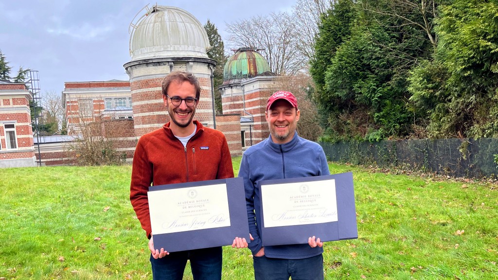 Twee mannen staan voor een koepel met officieel papier in hun handen